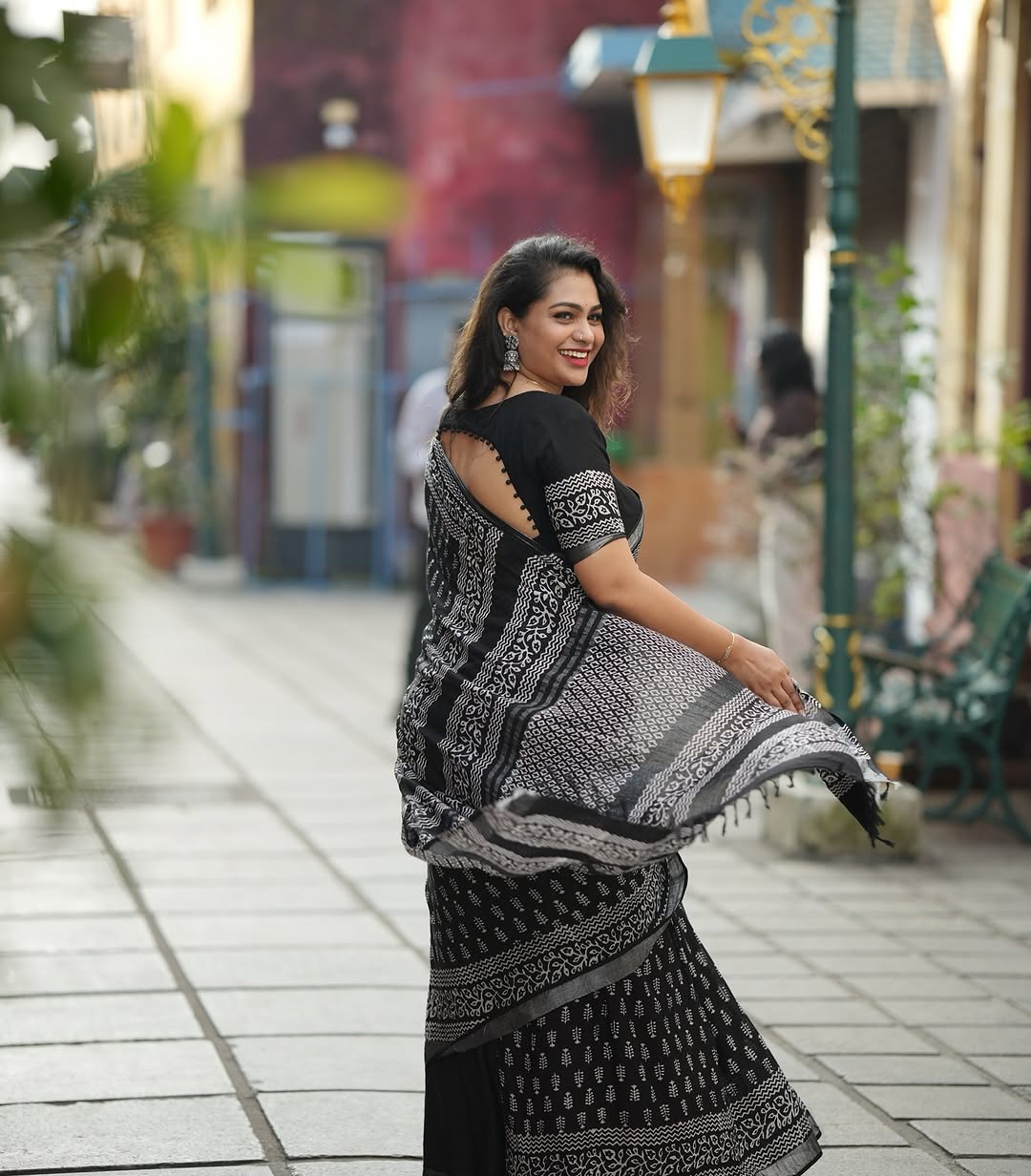 "Back view of the black linen digital print saree, highlighting its simple yet elegant design and the flowing fabric."