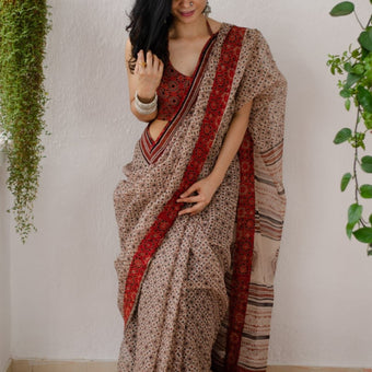 Model wearing a beige linen digital printed saree with floral motifs and matching blouse piece

